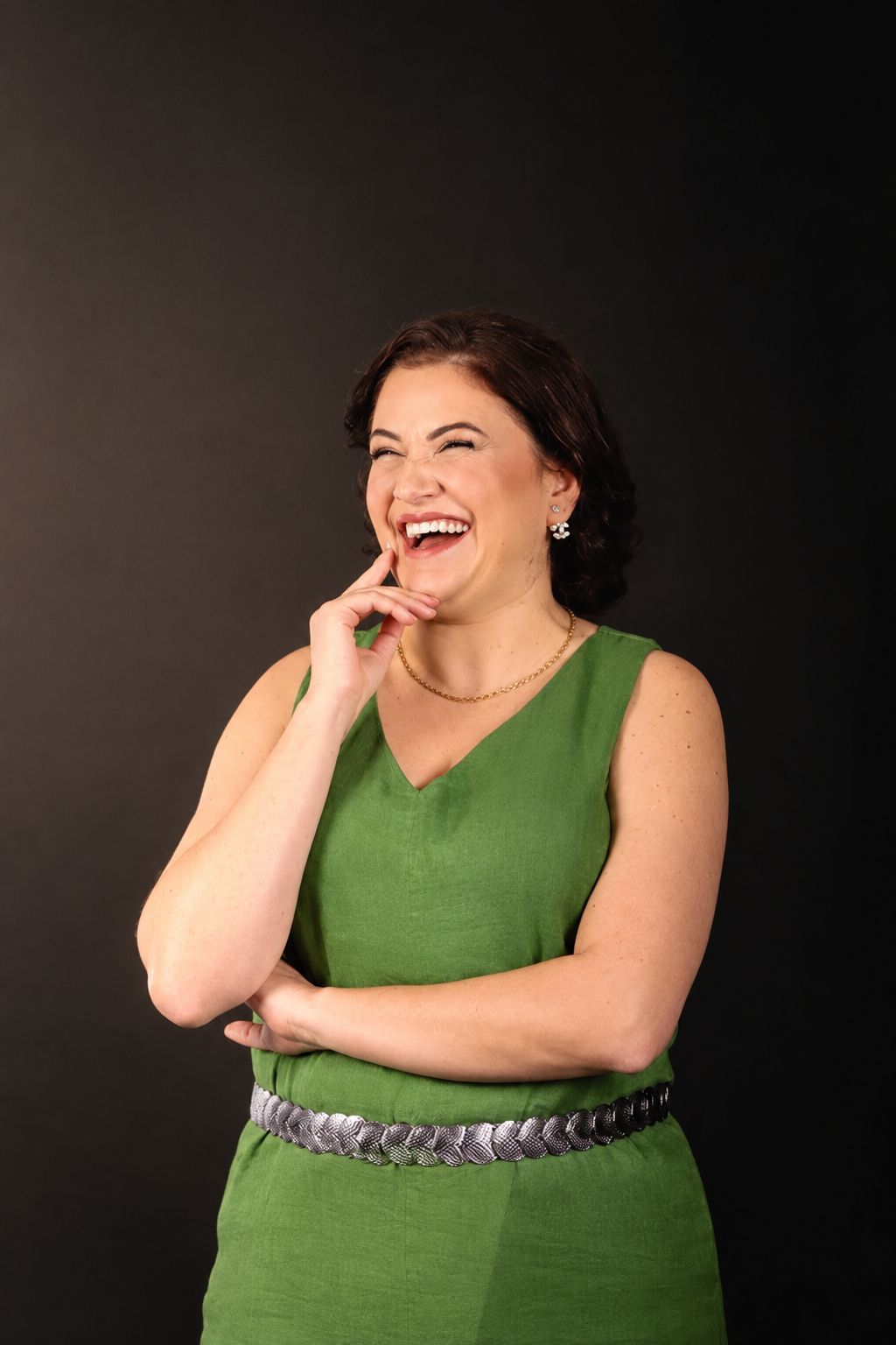Fernanda Carrozza sorrindo, de vestido verde, em retrato de estúdio